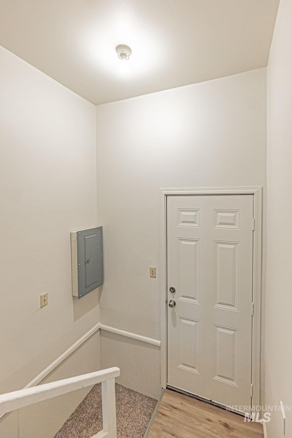 Foyer with electric panel and light wood finished floors