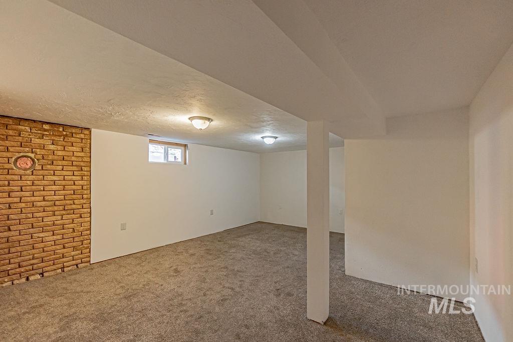 Below grade area with carpet and a textured ceiling