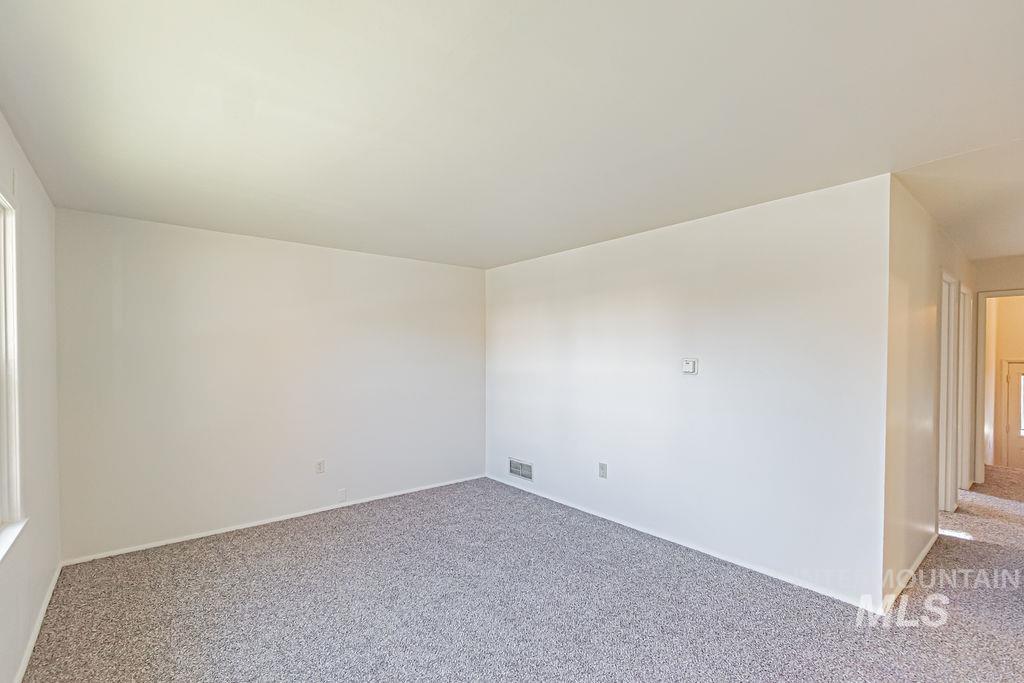 Carpeted empty room with baseboards