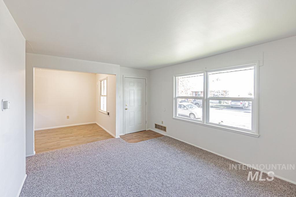 Spare room featuring light colored carpet and healthy amount of natural light