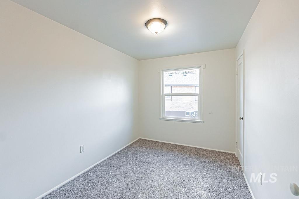 Carpeted empty room featuring baseboards