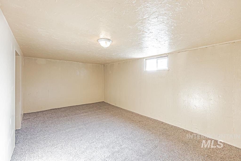 Below grade area featuring light colored carpet and a textured ceiling