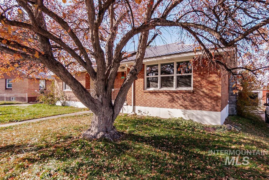 View of side of home featuring brick siding and a yard