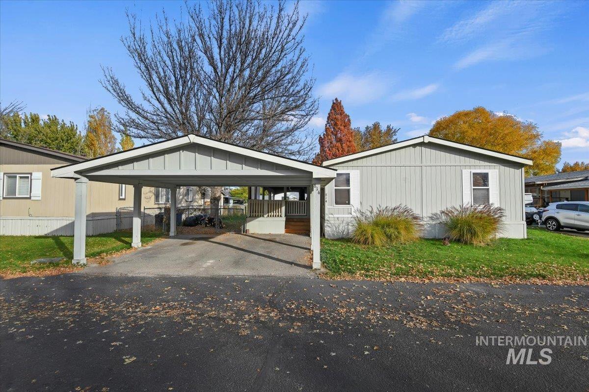 View of home's exterior with a detached carport, driveway, a porch, and board and batten siding
