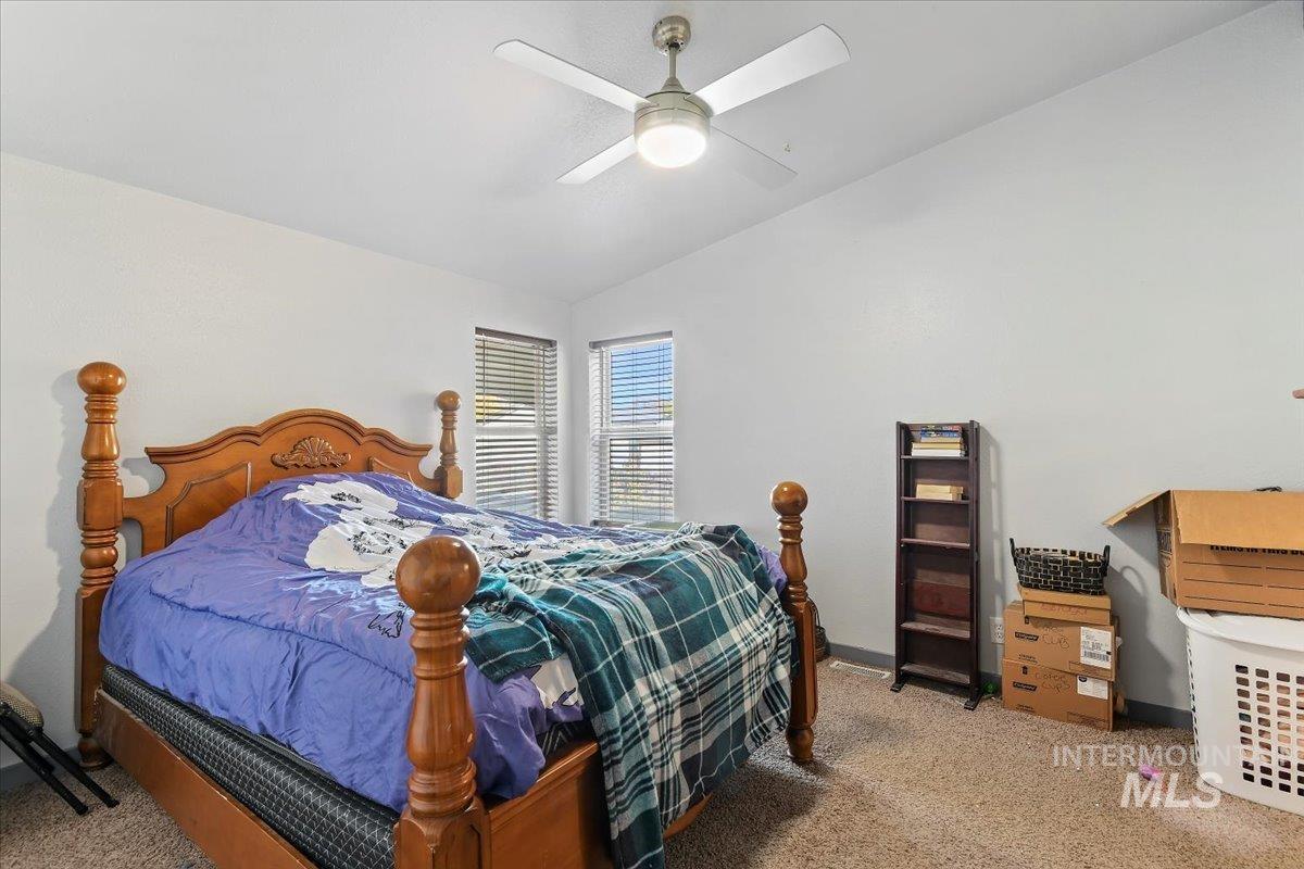 Bedroom featuring vaulted ceiling, carpet, and ceiling fan