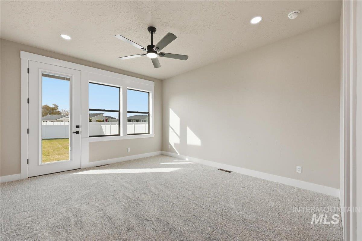 Carpeted spare room with a ceiling fan, a textured ceiling, and recessed lighting