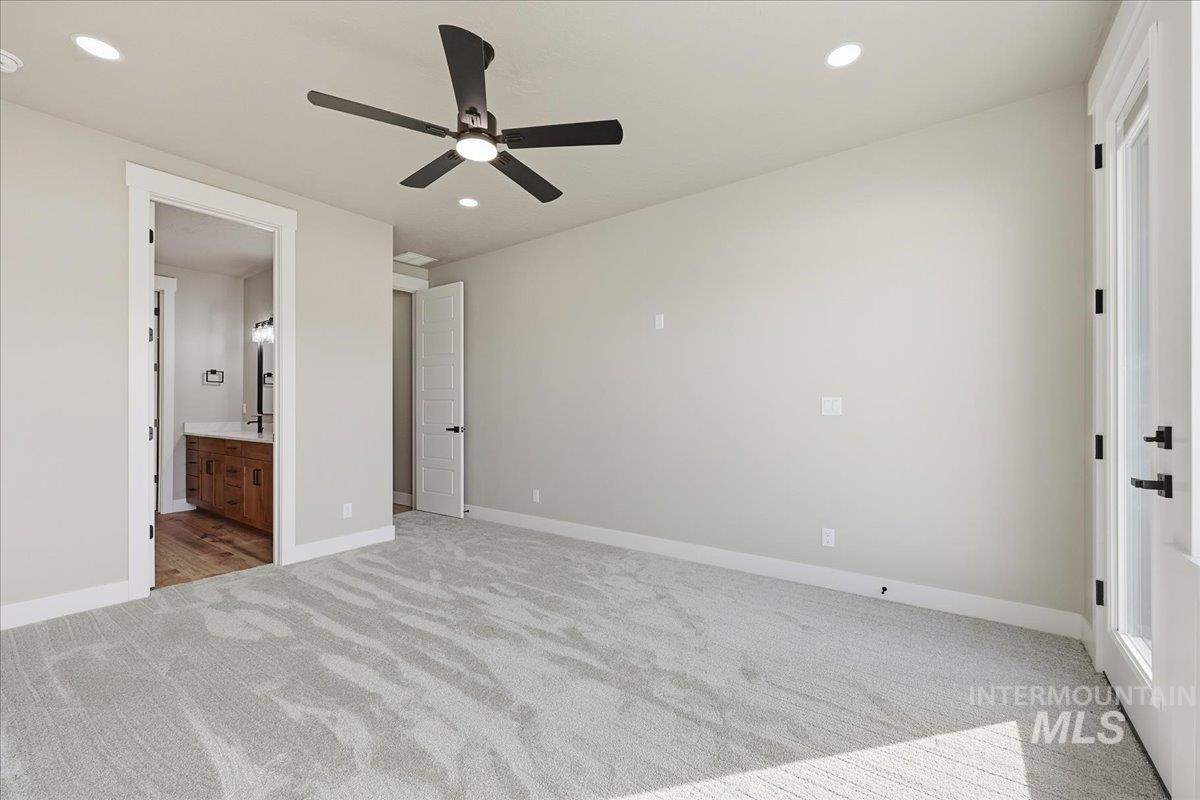 Unfurnished bedroom with light carpet, ensuite bath, recessed lighting, and ceiling fan