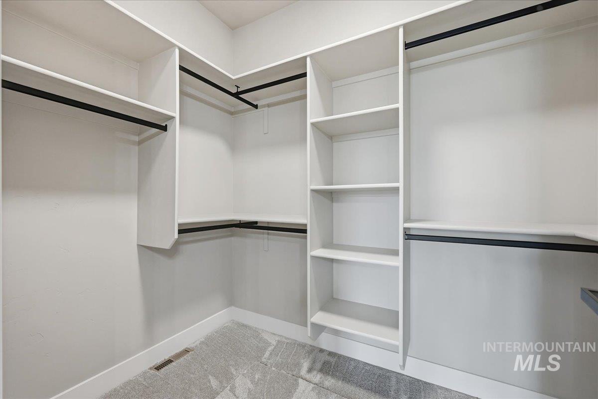 Spacious closet with light carpet