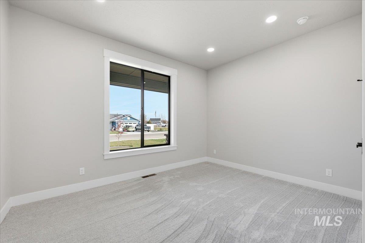 Spare room featuring light colored carpet and recessed lighting