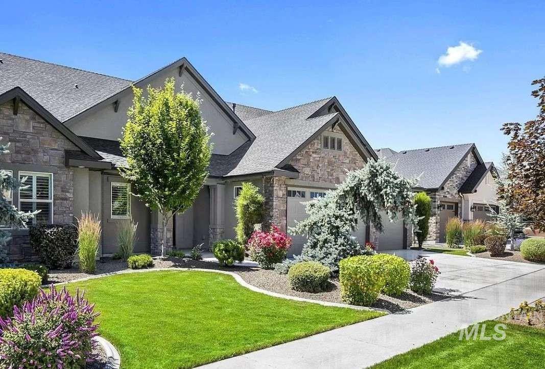 Craftsman-style house featuring stone siding, concrete driveway, a front lawn, an attached garage, and stucco siding