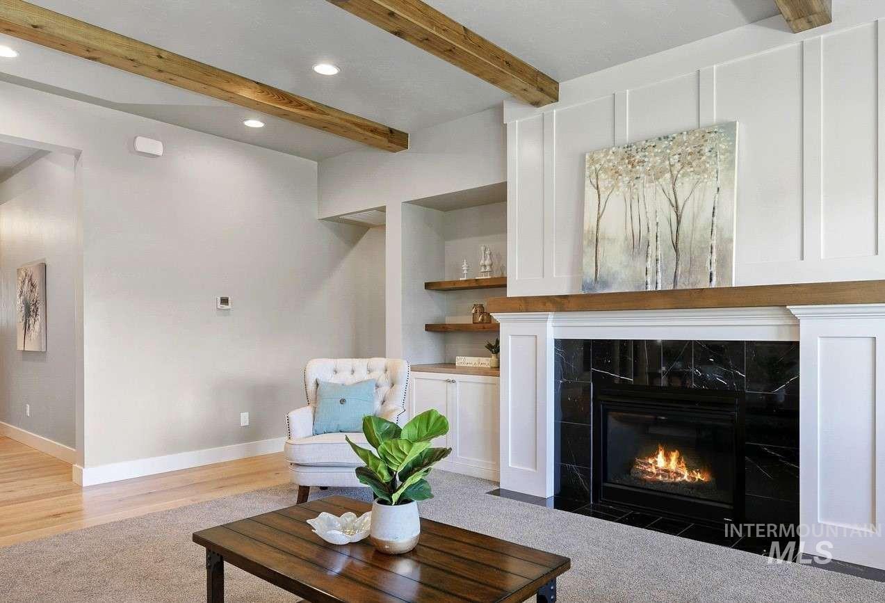Living area featuring a fireplace, beamed ceiling, recessed lighting, and wood finished floors
