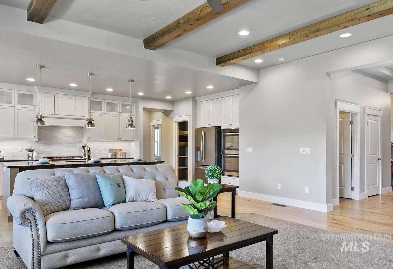 Living room featuring recessed lighting, beamed ceiling, and light wood-style floors