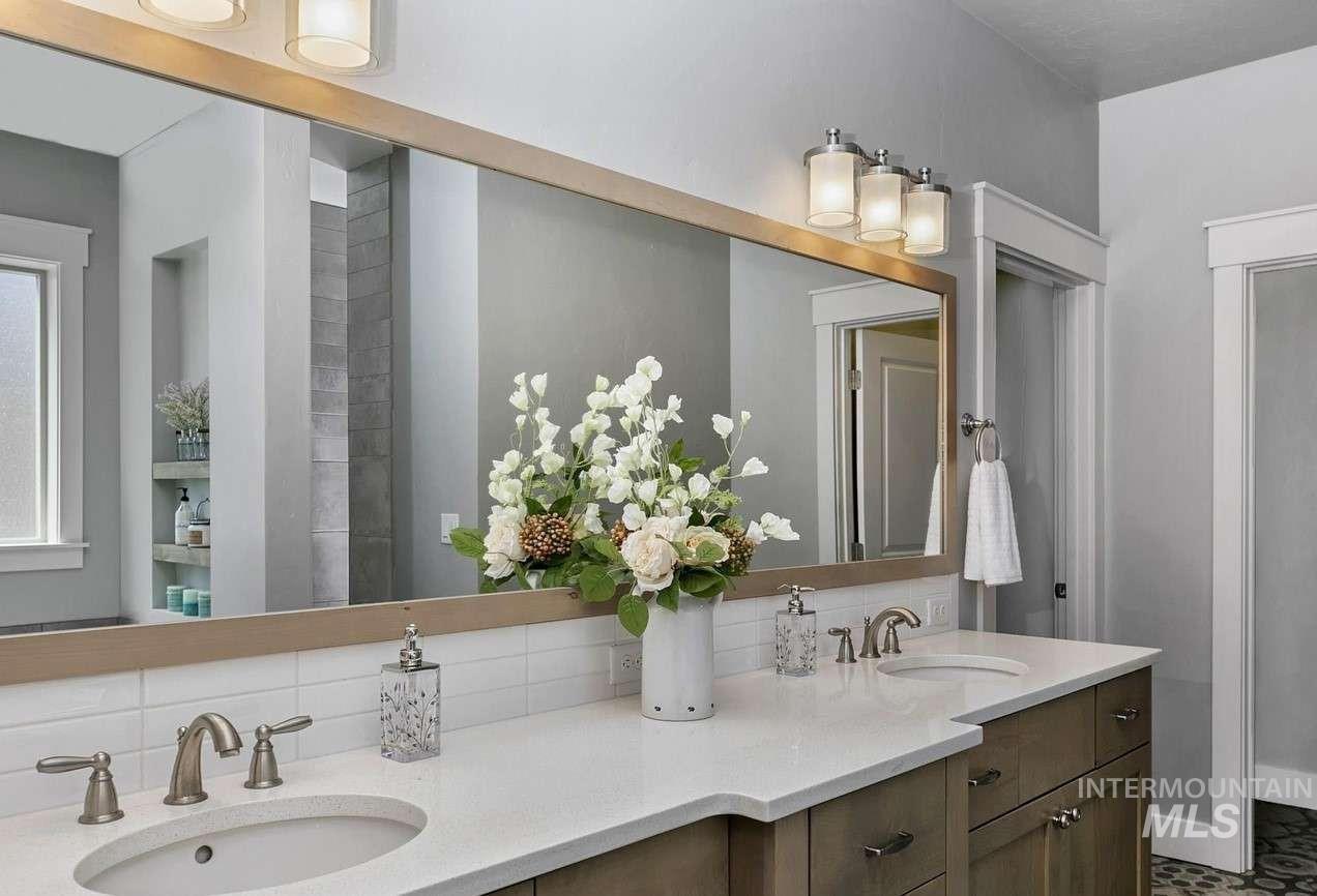 Full bathroom featuring double vanity and backsplash