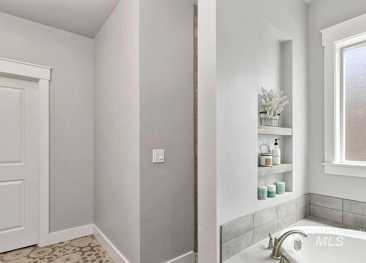 Bathroom featuring healthy amount of natural light, a garden tub, and tile patterned flooring