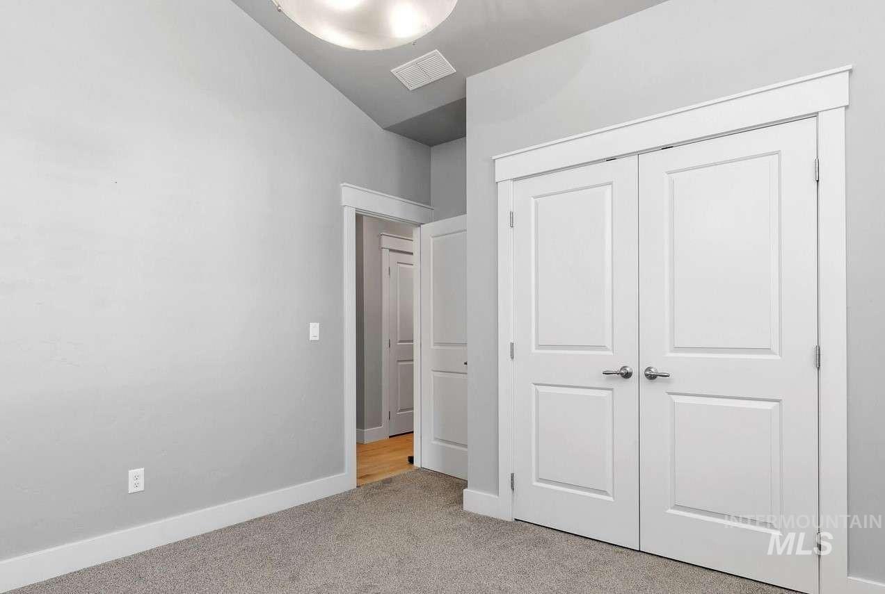 Unfurnished bedroom with light colored carpet and a closet