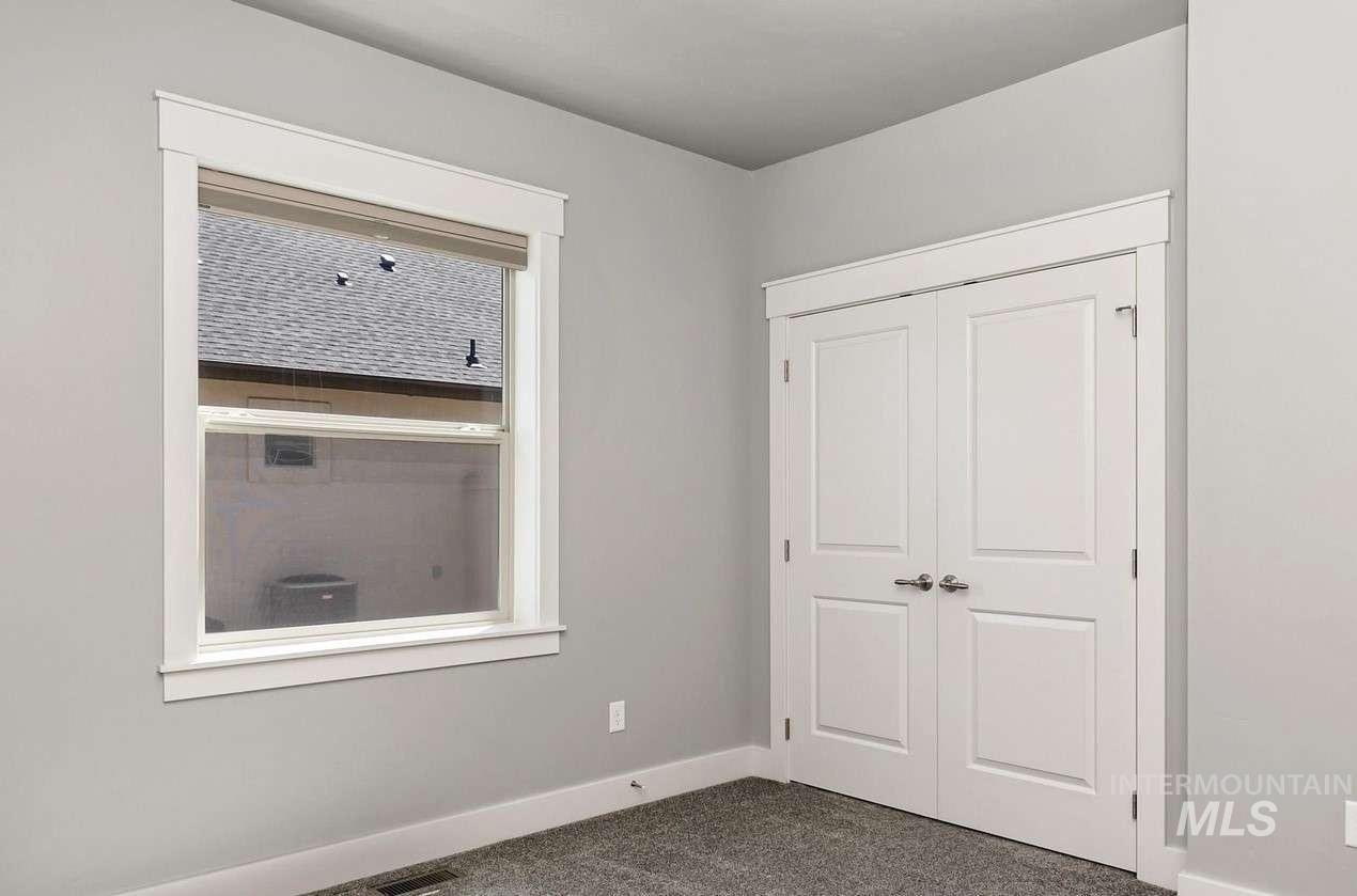 Unfurnished bedroom with dark colored carpet and a closet