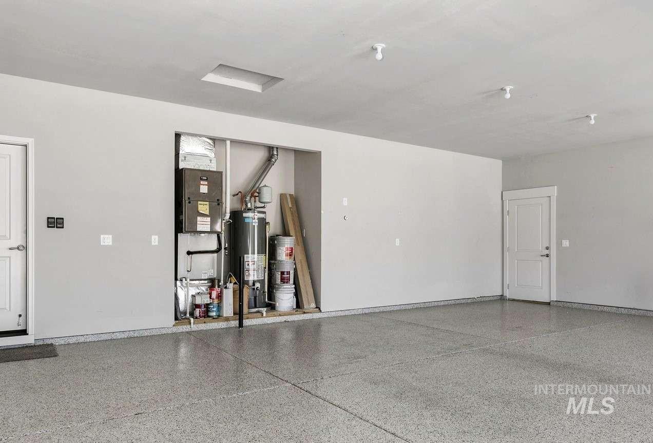 Garage featuring water heater and heating unit