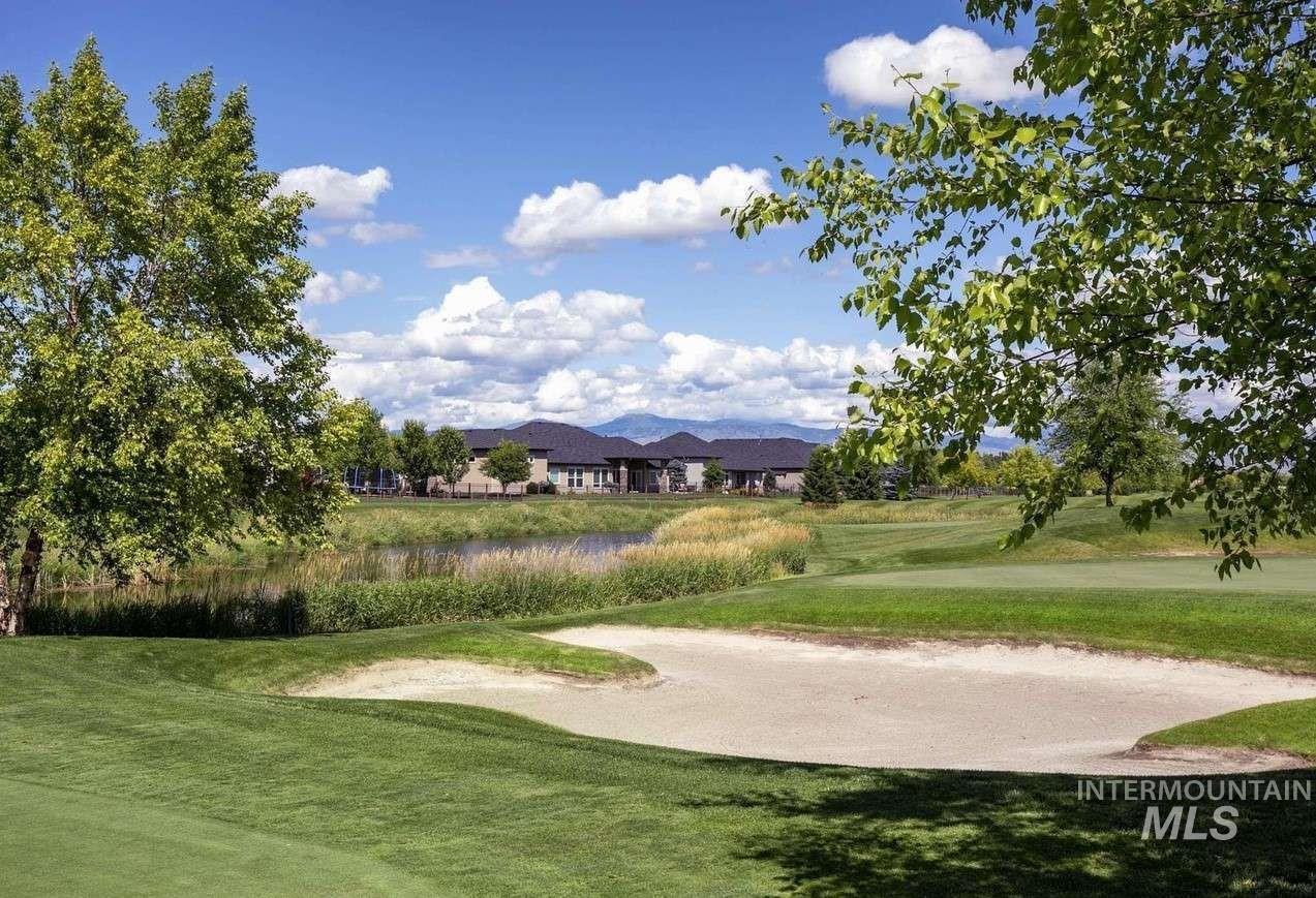 View of home's community with a mountain view, a yard, and view of golf course