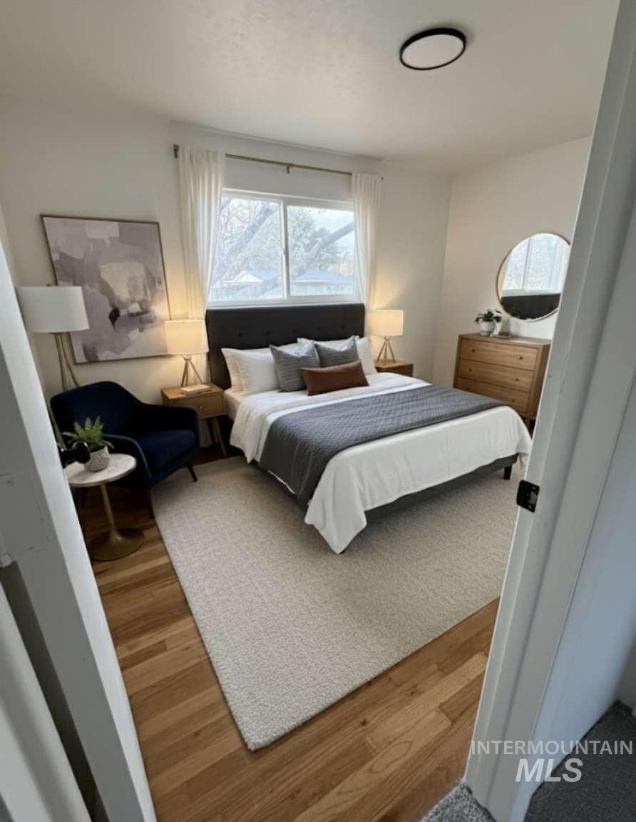 Bedroom featuring multiple windows and wood finished floors