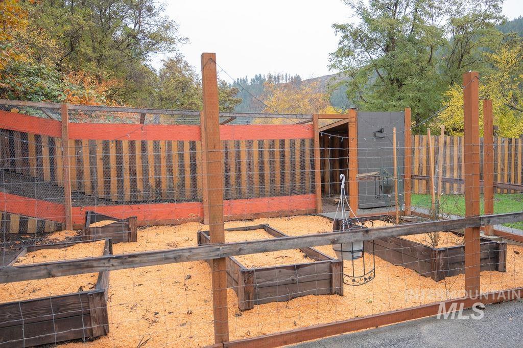Enclosed garden area with maintained raised beds and attached chicken coop area.
