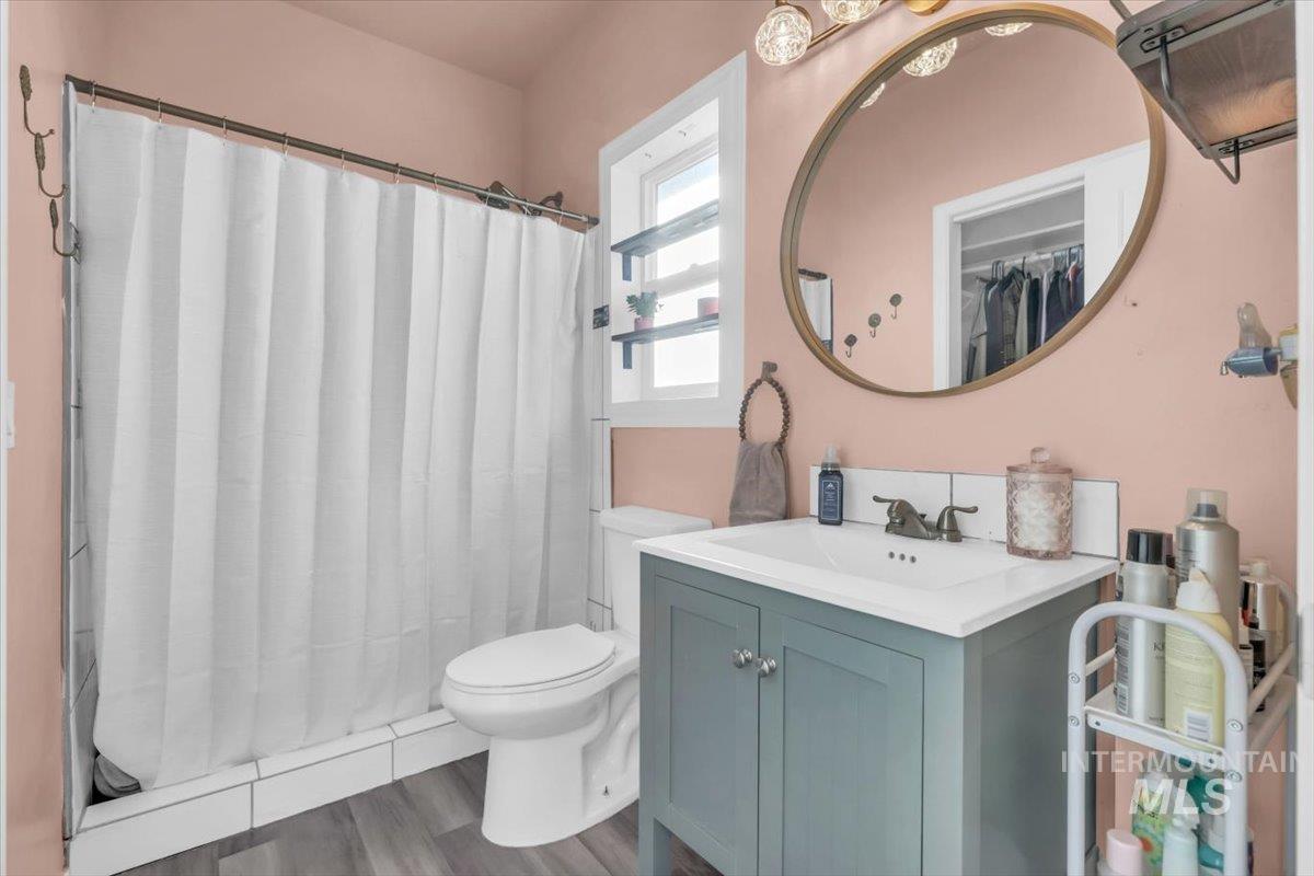Bathroom with vanity, a shower with curtain, and dark wood-style floors