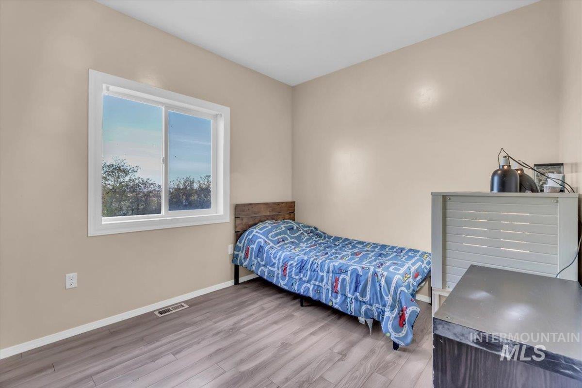 Bedroom with baseboards and wood finished floors