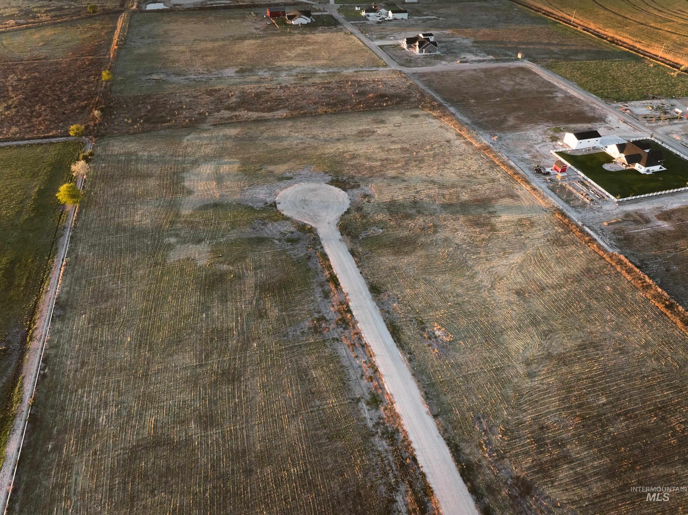 Aerial view of property and surrounding area featuring rural landscape and large plots for crops