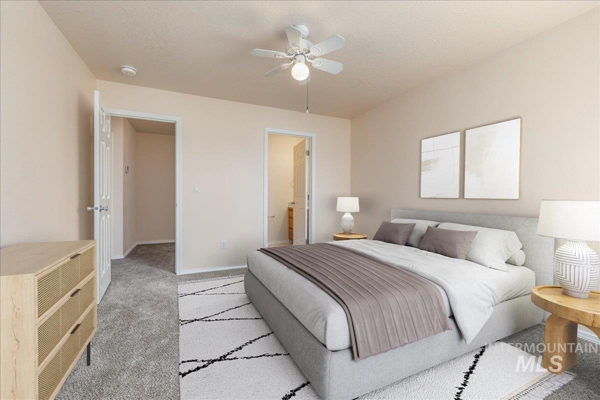 Carpeted bedroom featuring ensuite bath, a textured ceiling, and a ceiling fan