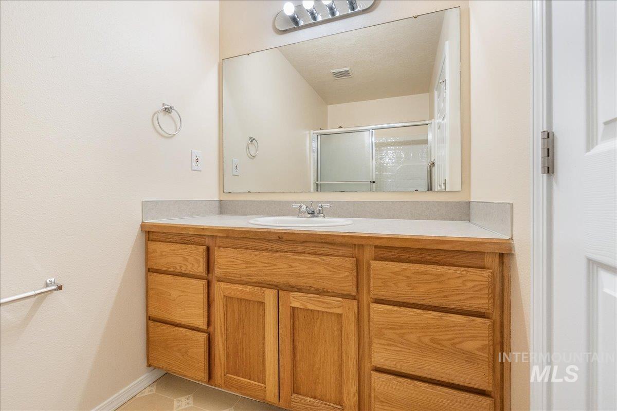 Bathroom with a stall shower, vanity, and light tile patterned floors