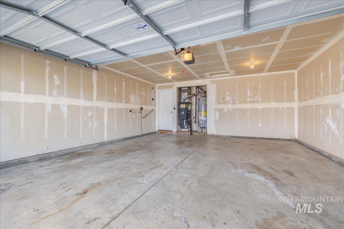 Garage featuring gas water heater and a garage door opener