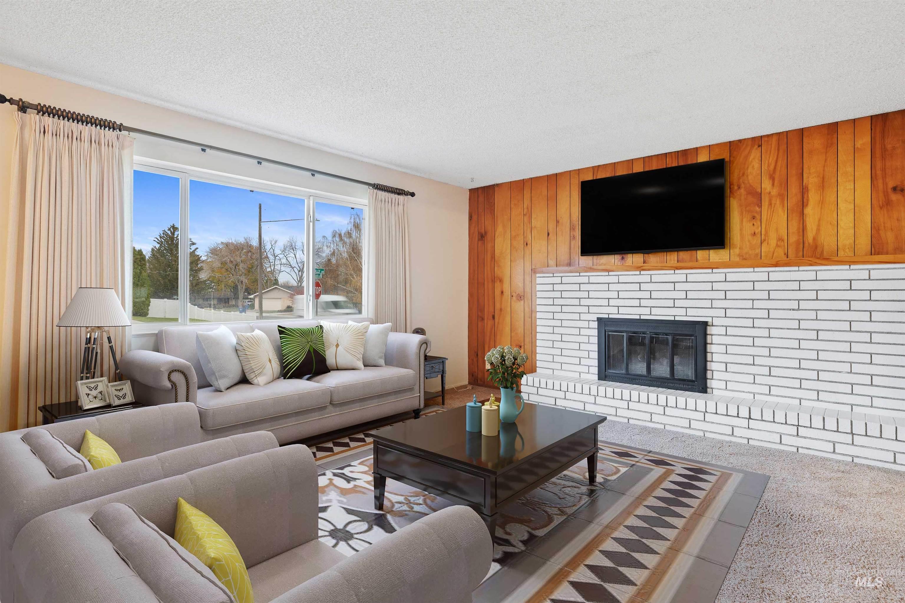 Living room with wooden walls, carpet flooring, a fireplace, and a textured ceiling