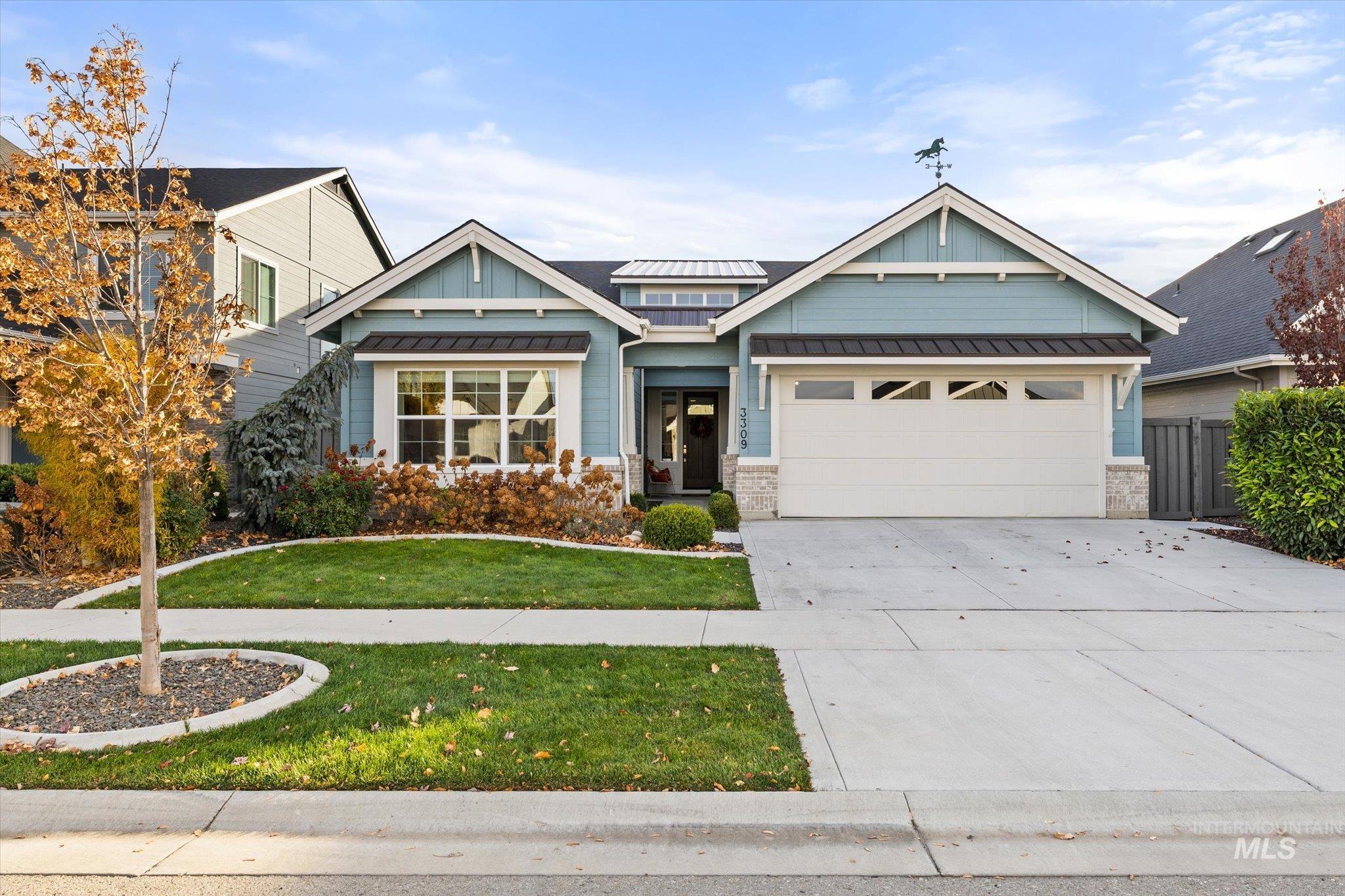 Craftsman house featuring a standing seam roof, a metal roof, and driveway