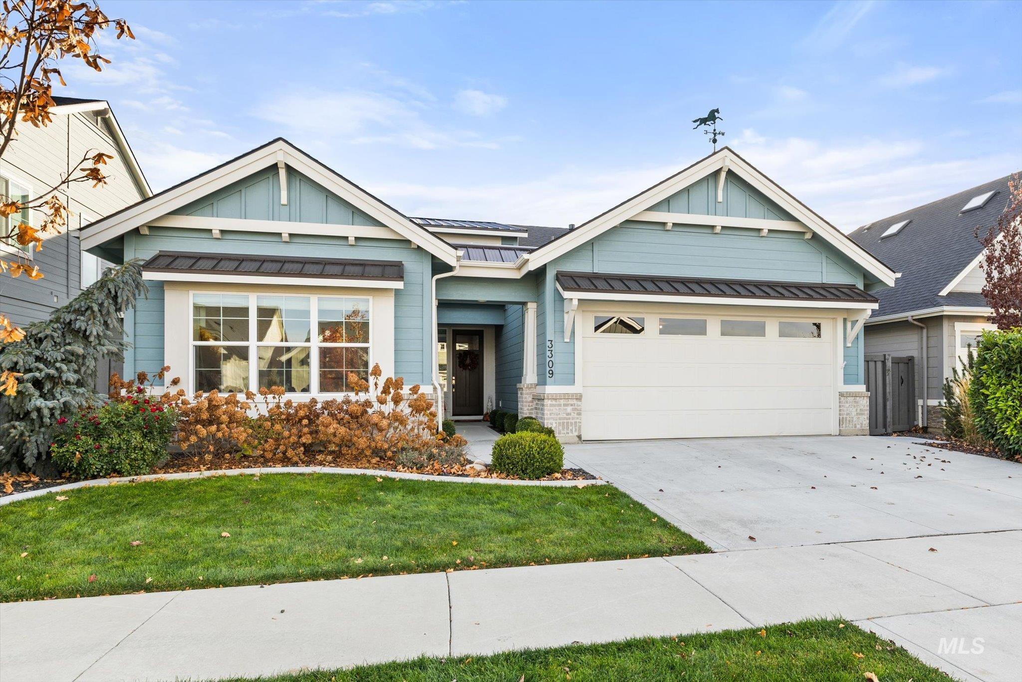 Craftsman inspired home with board and batten siding, driveway, a front yard, a metal roof, and a standing seam roof