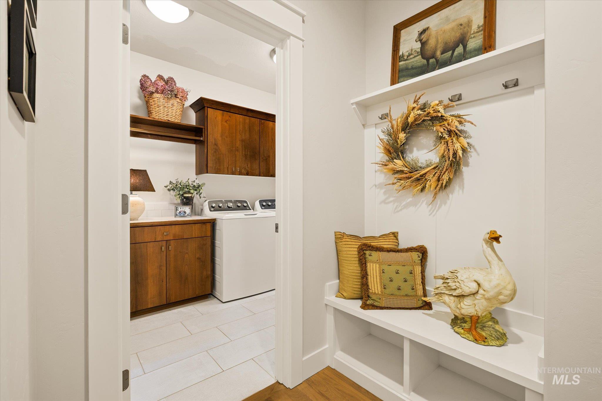 Laundry room featuring cabinet space, washer and clothes dryer, and light wood-type flooring