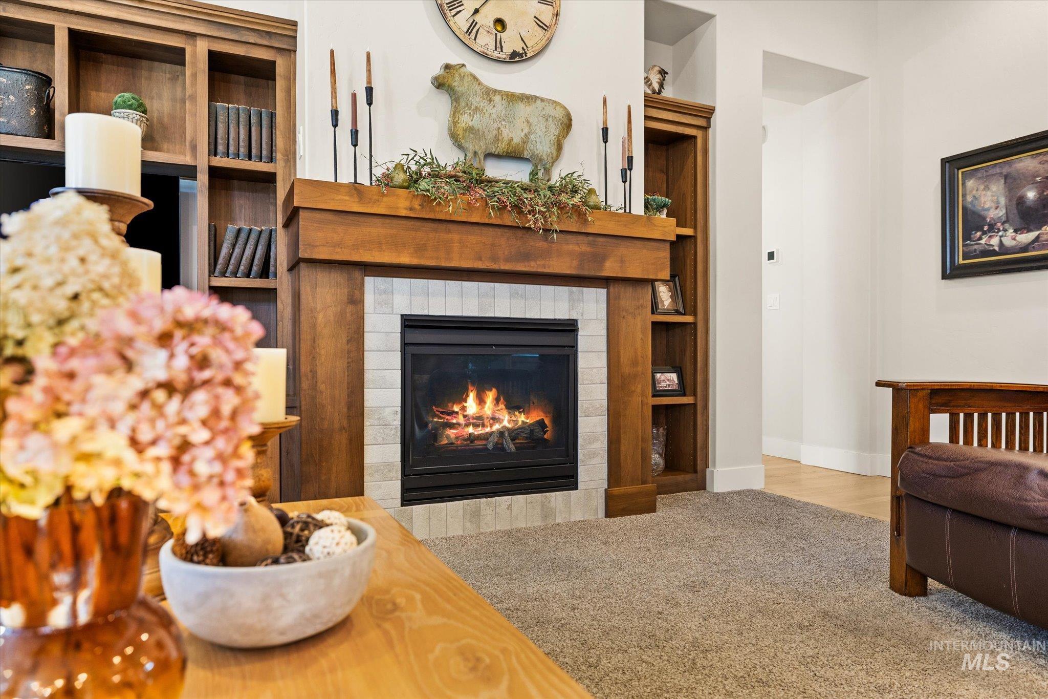 Carpeted living room featuring a tiled fireplace and baseboards