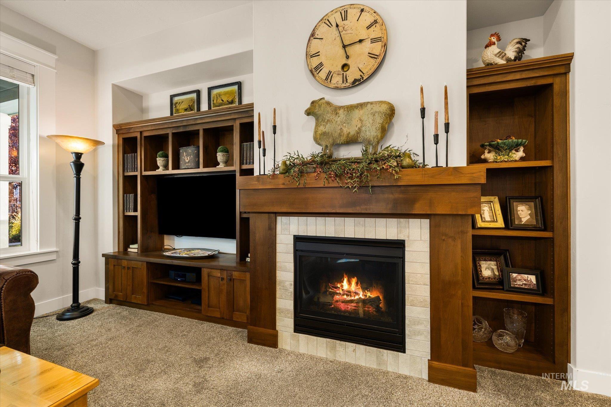 Living room with carpet floors and a glass covered fireplace