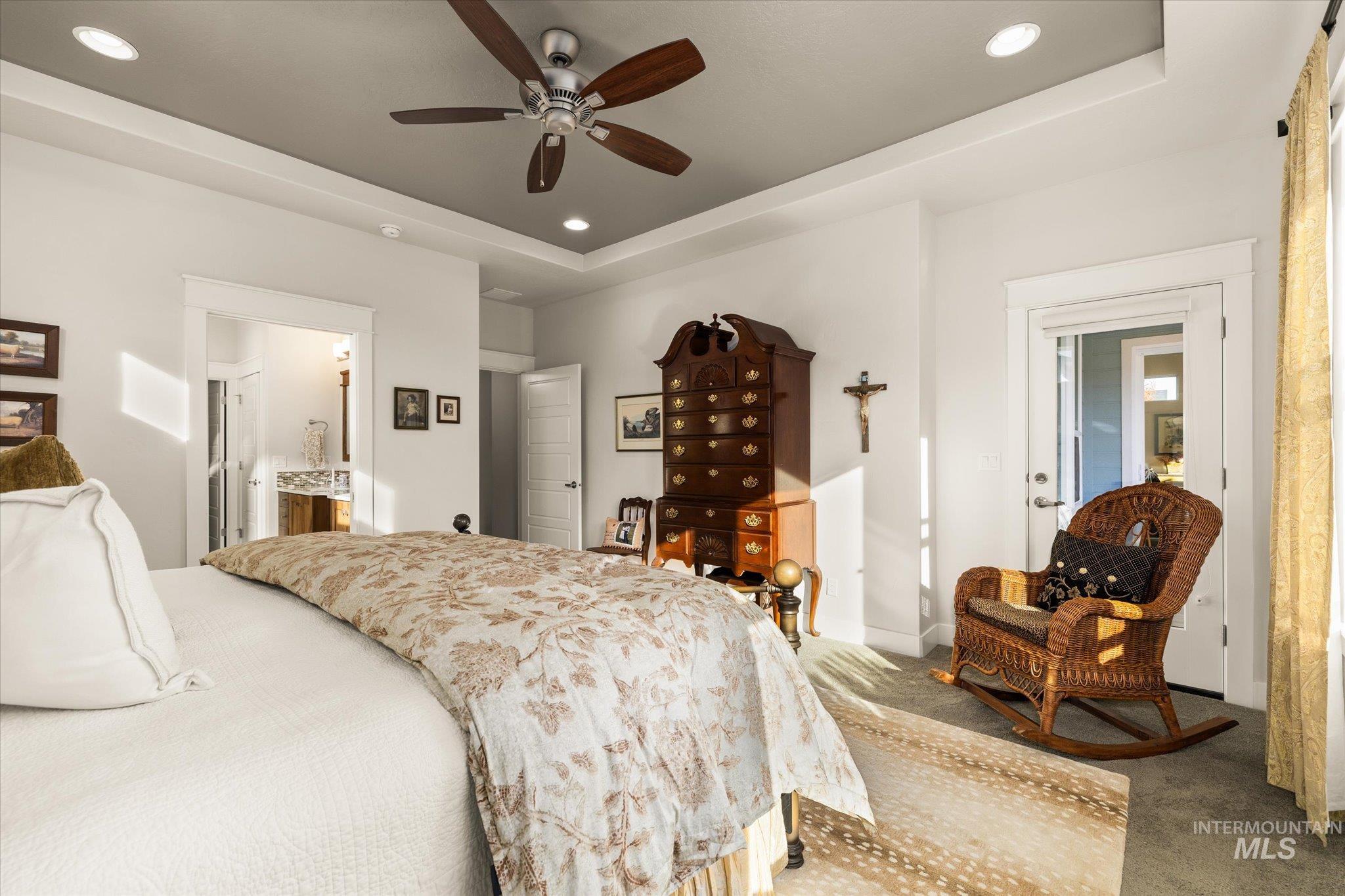Bedroom with a tray ceiling, recessed lighting, carpet, connected bathroom, and ceiling fan