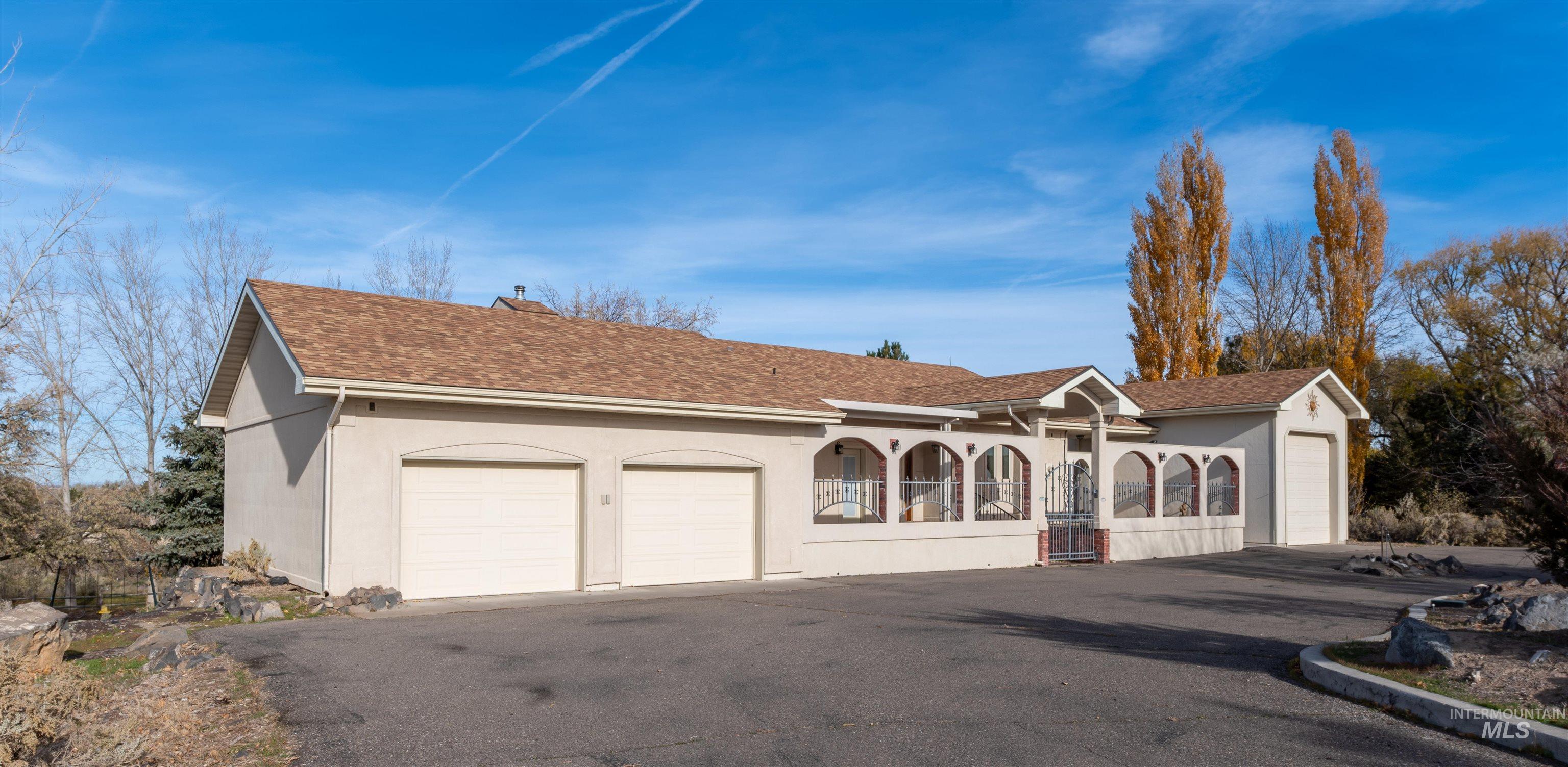 View of front of property featuring stucco siding and roof with shingles