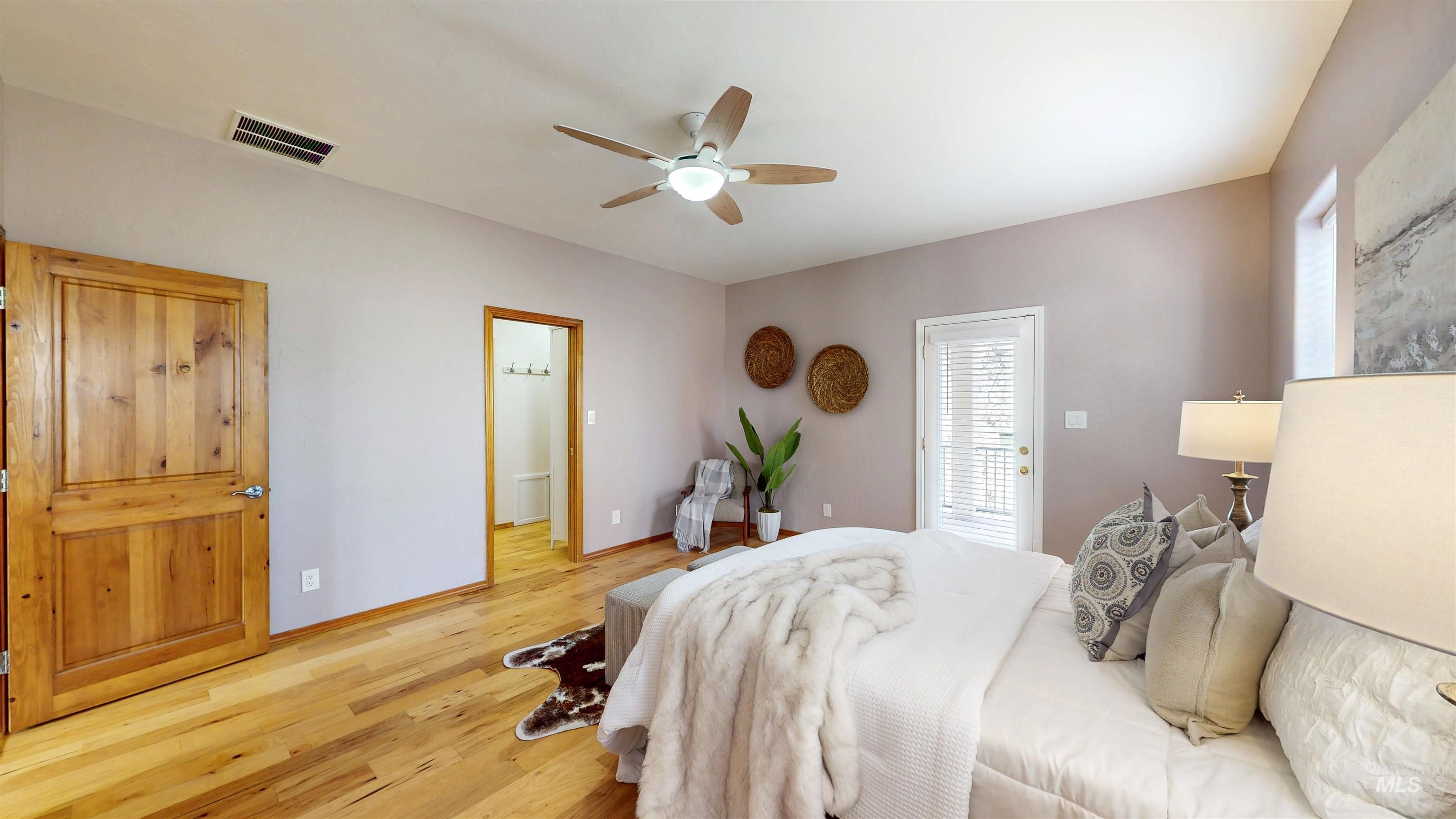 Bedroom with wood finished floors, ceiling fan, and access to exterior deck