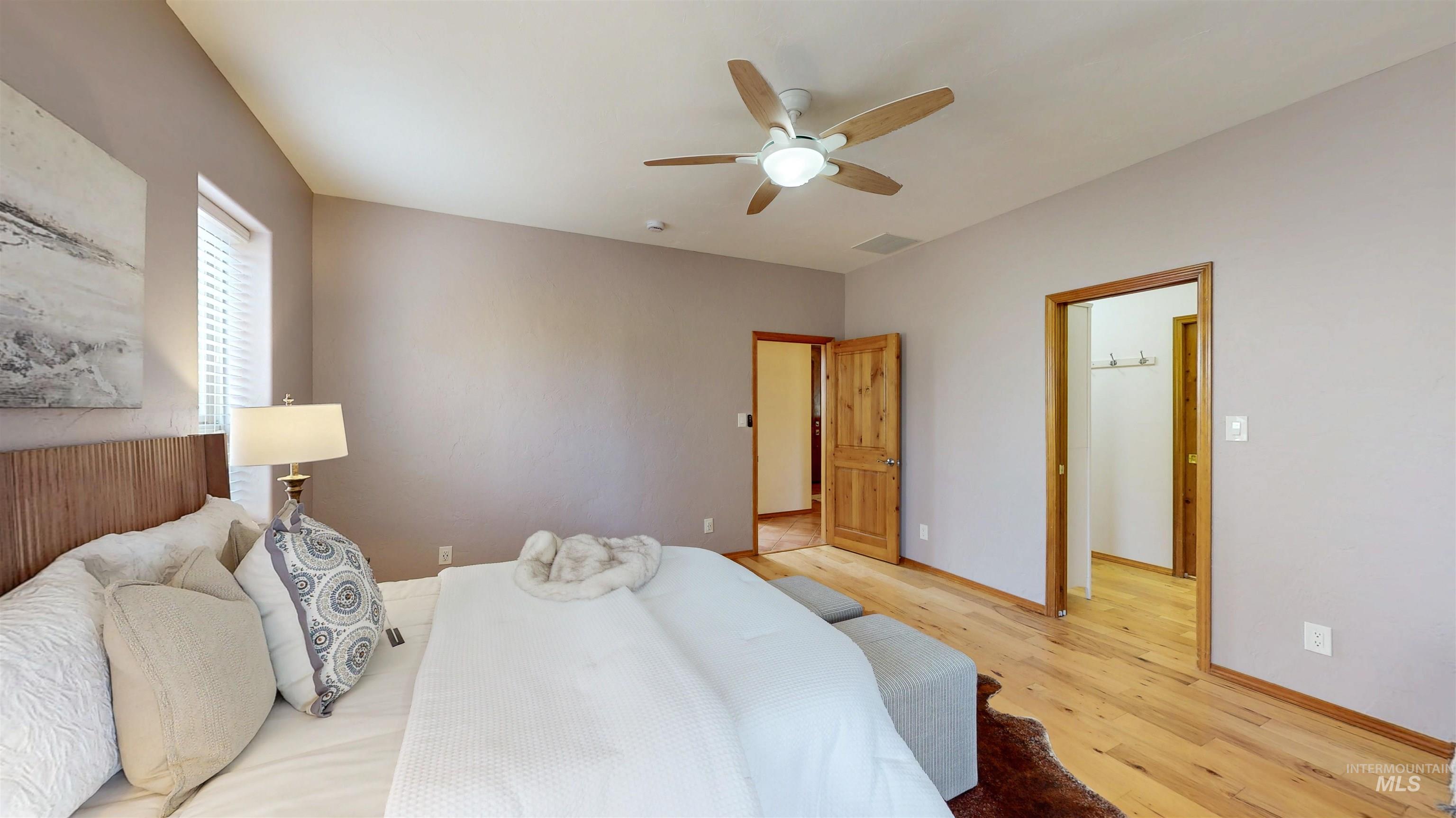 Bedroom with light wood flooring and ceiling fan
