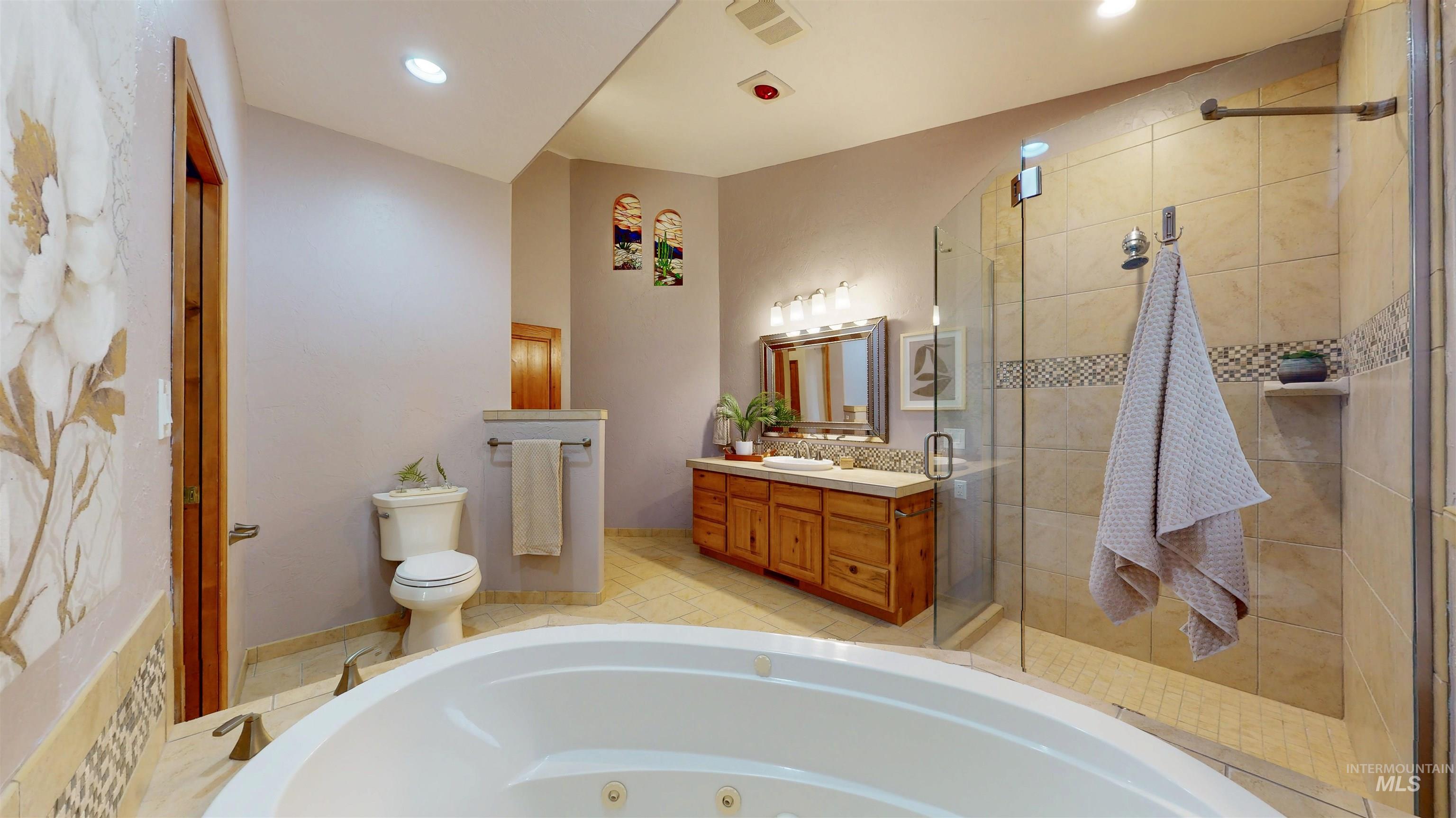 Bathroom with vanity, a whirlpool tub, a shower stall, and recessed lighting
