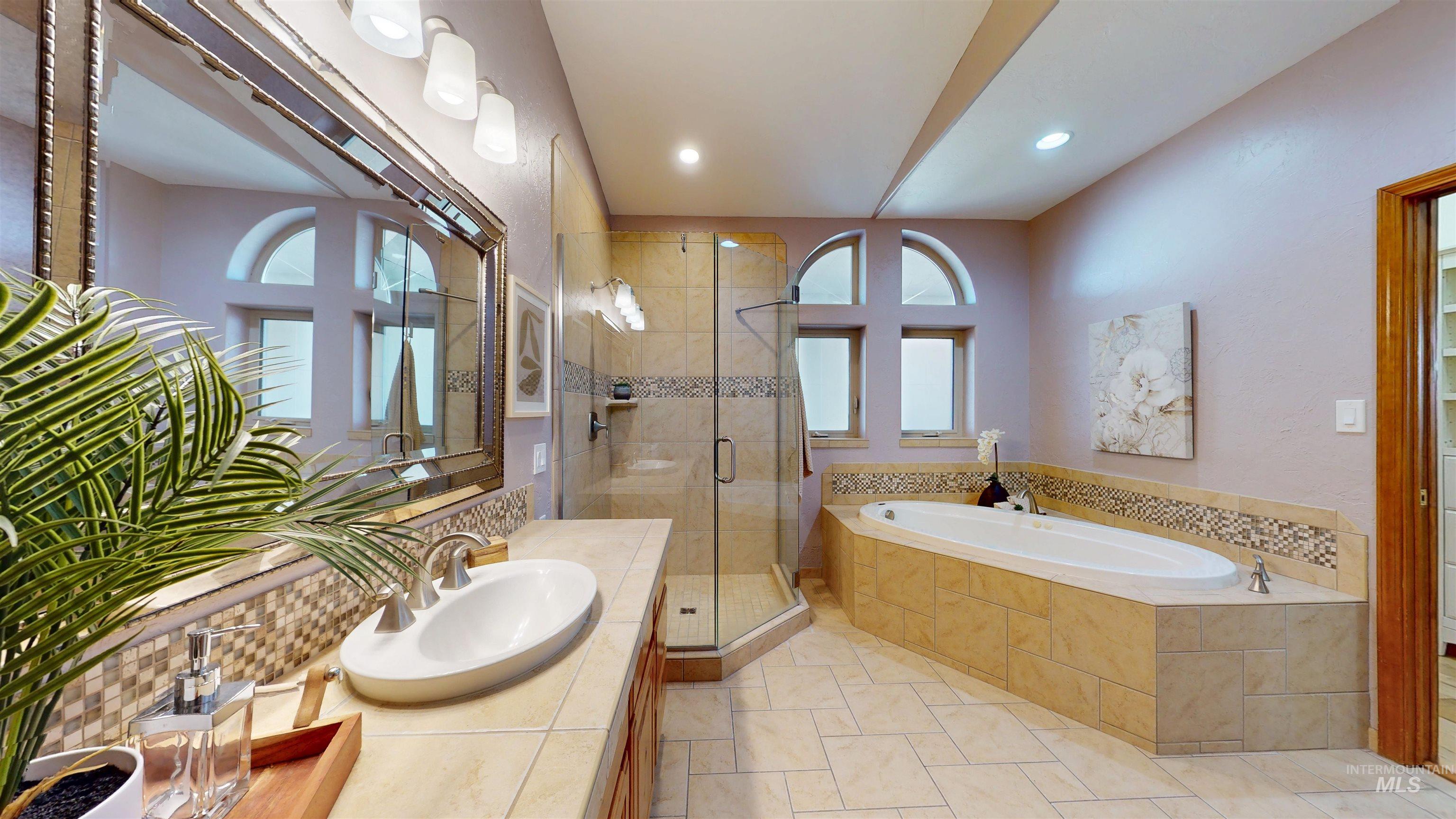 Full bath featuring a shower stall, vanity, a bath, light tile patterned floors, and recessed lighting