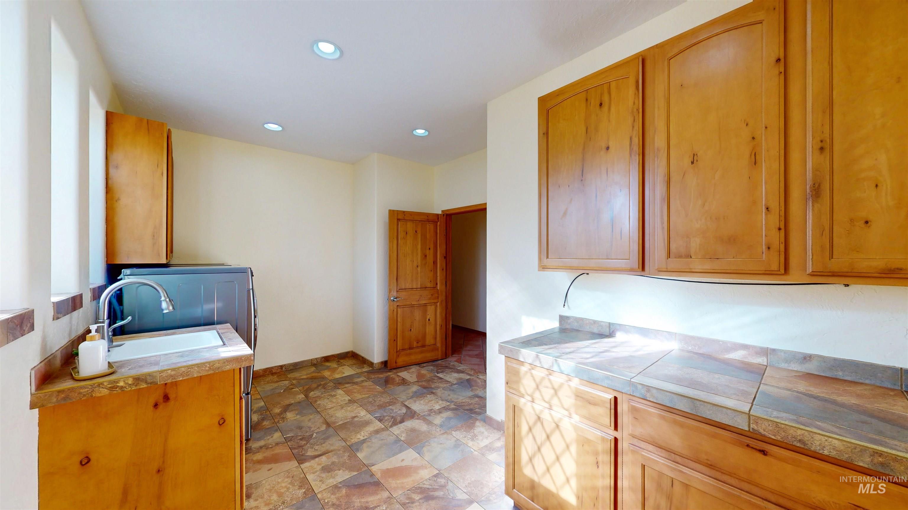 Laundry featuring recessed lighting, stone finish floors, and washer / dryer