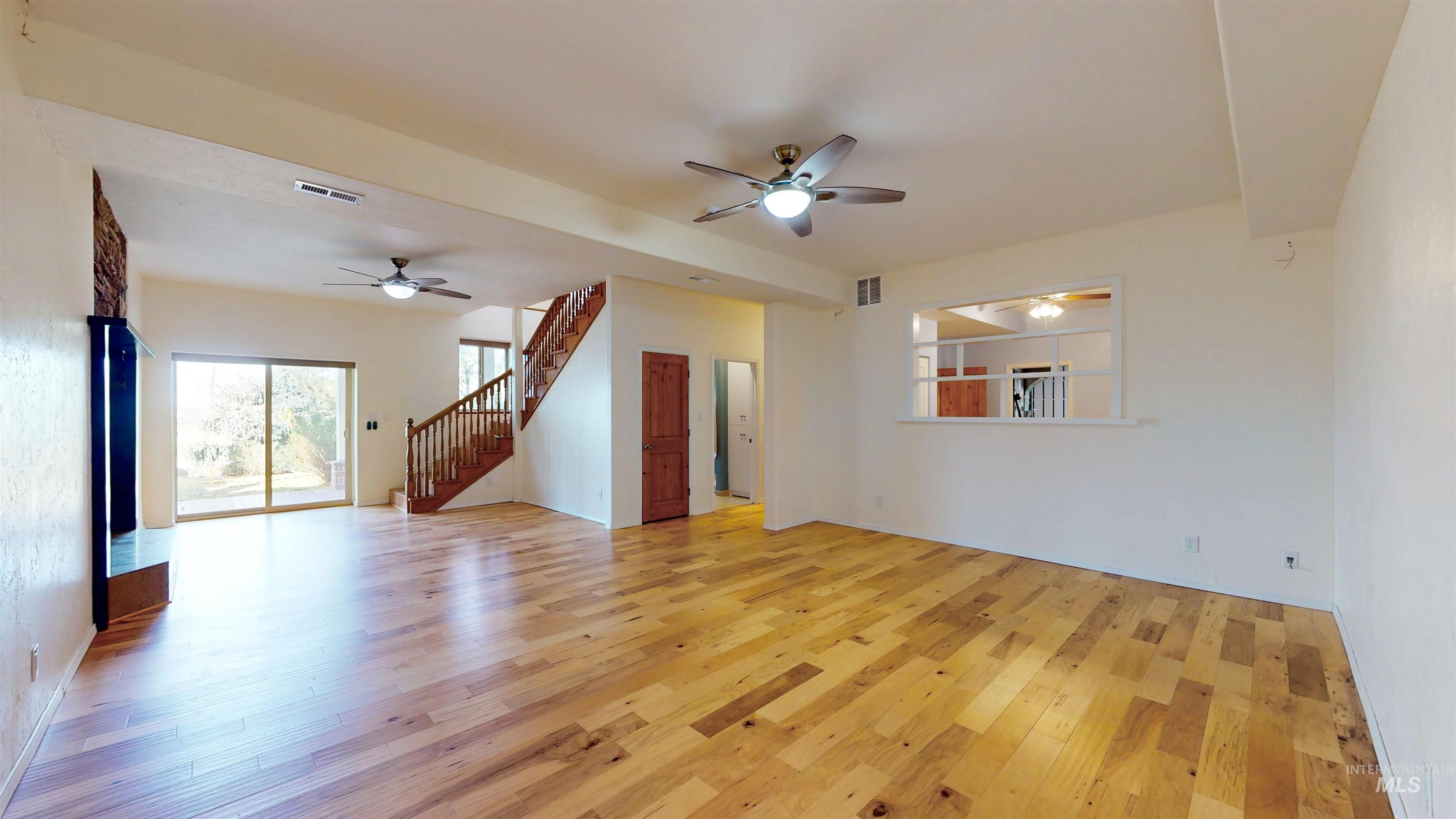 Recreational room featuring ceiling fan, light wood flooring, and stairs