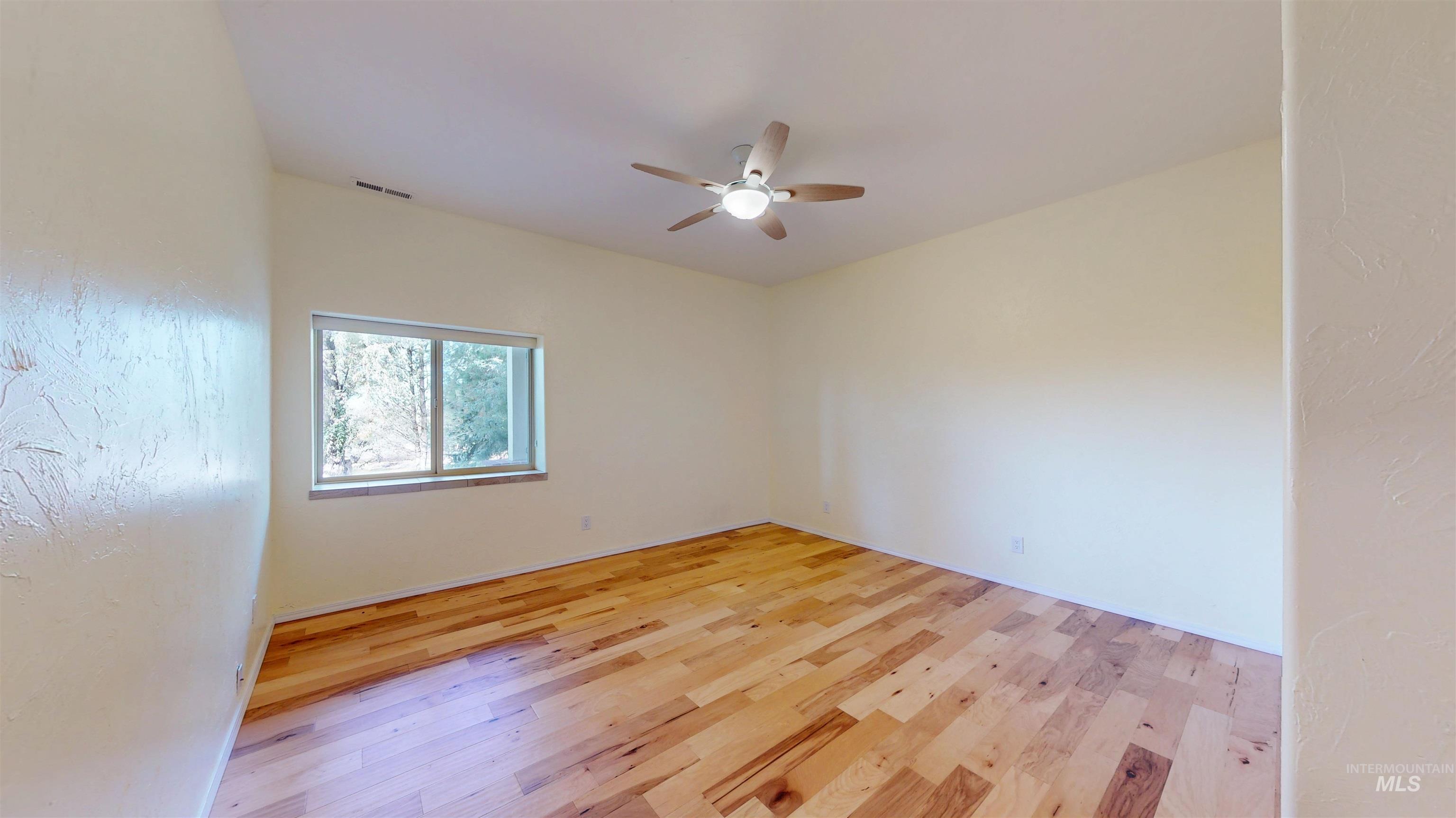 Bedroom with light wood finished floors and a ceiling fan