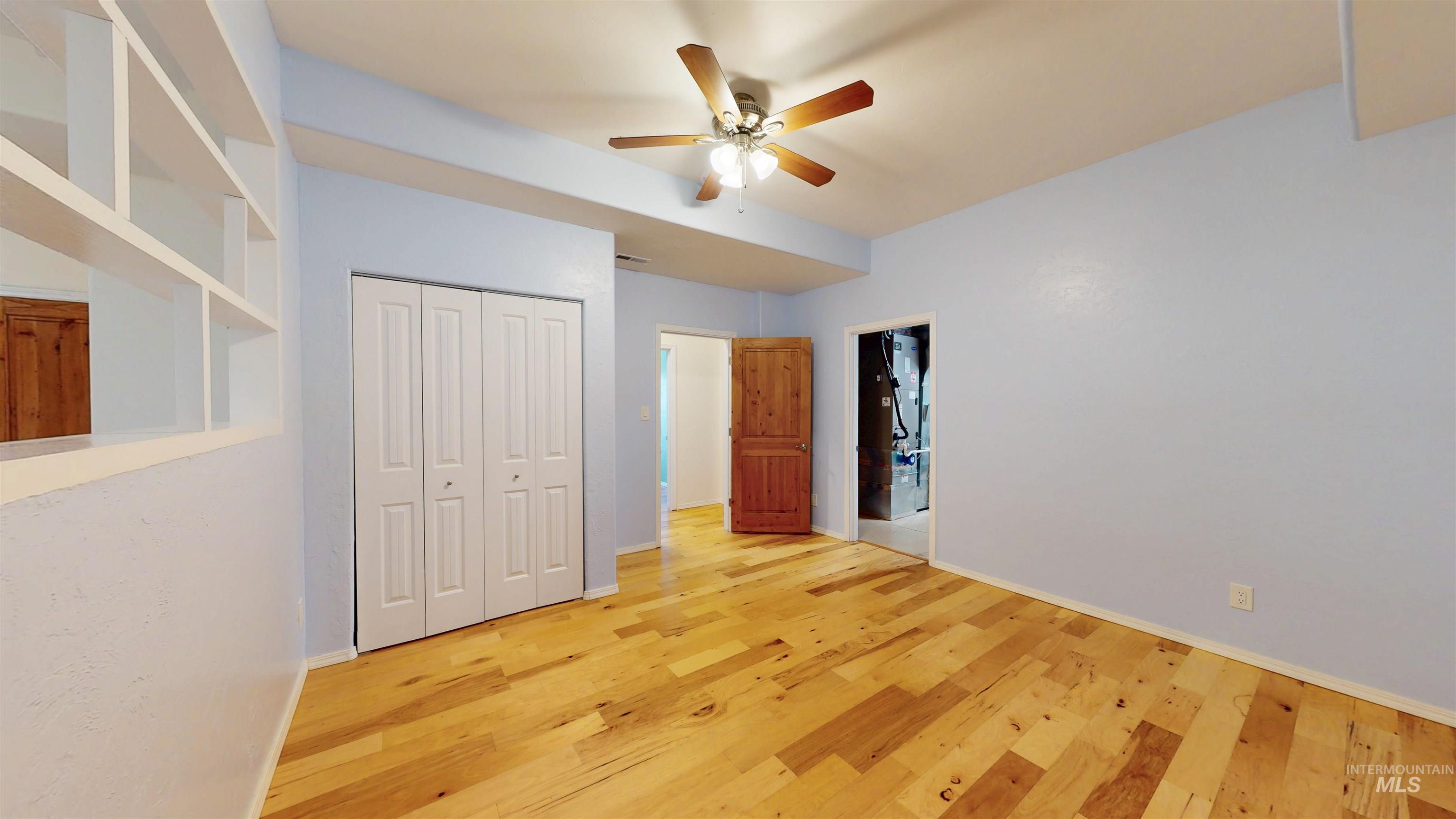 Swing room with wood finished floors, ceiling fan, and a closet