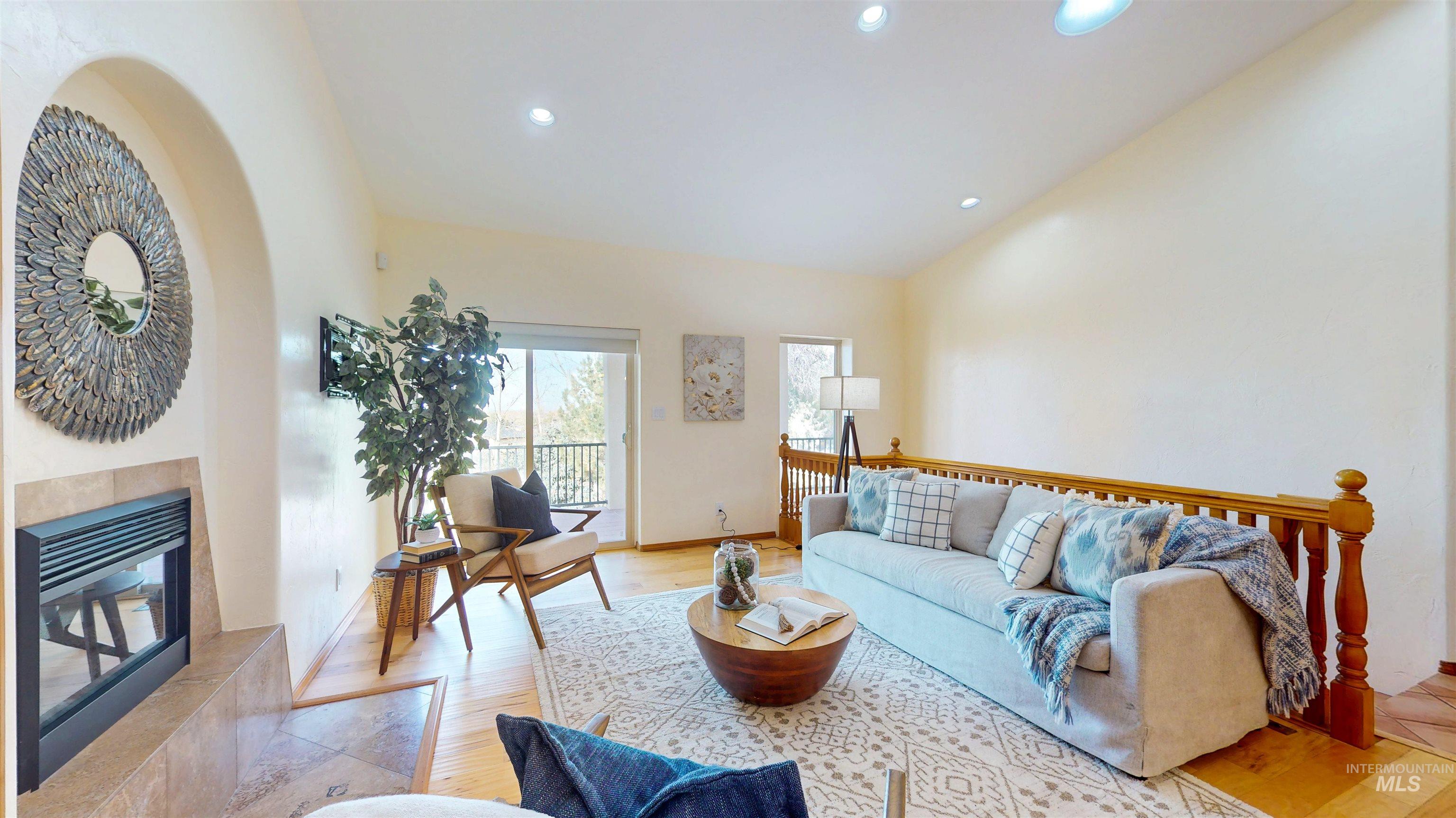Great room with recessed lighting, a tile fireplace, and light wood flooring