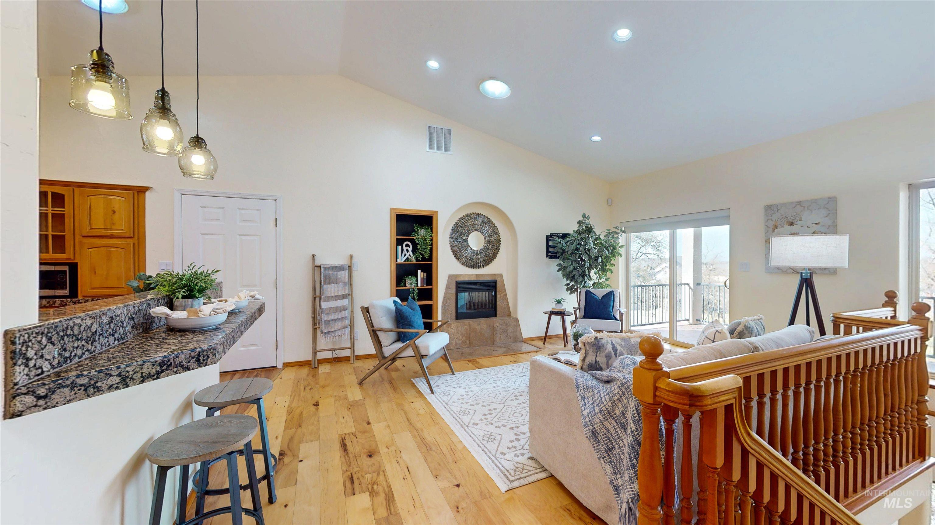 Great Room featuring a fireplace, recessed lighting, light wood floors, and high vaulted ceiling