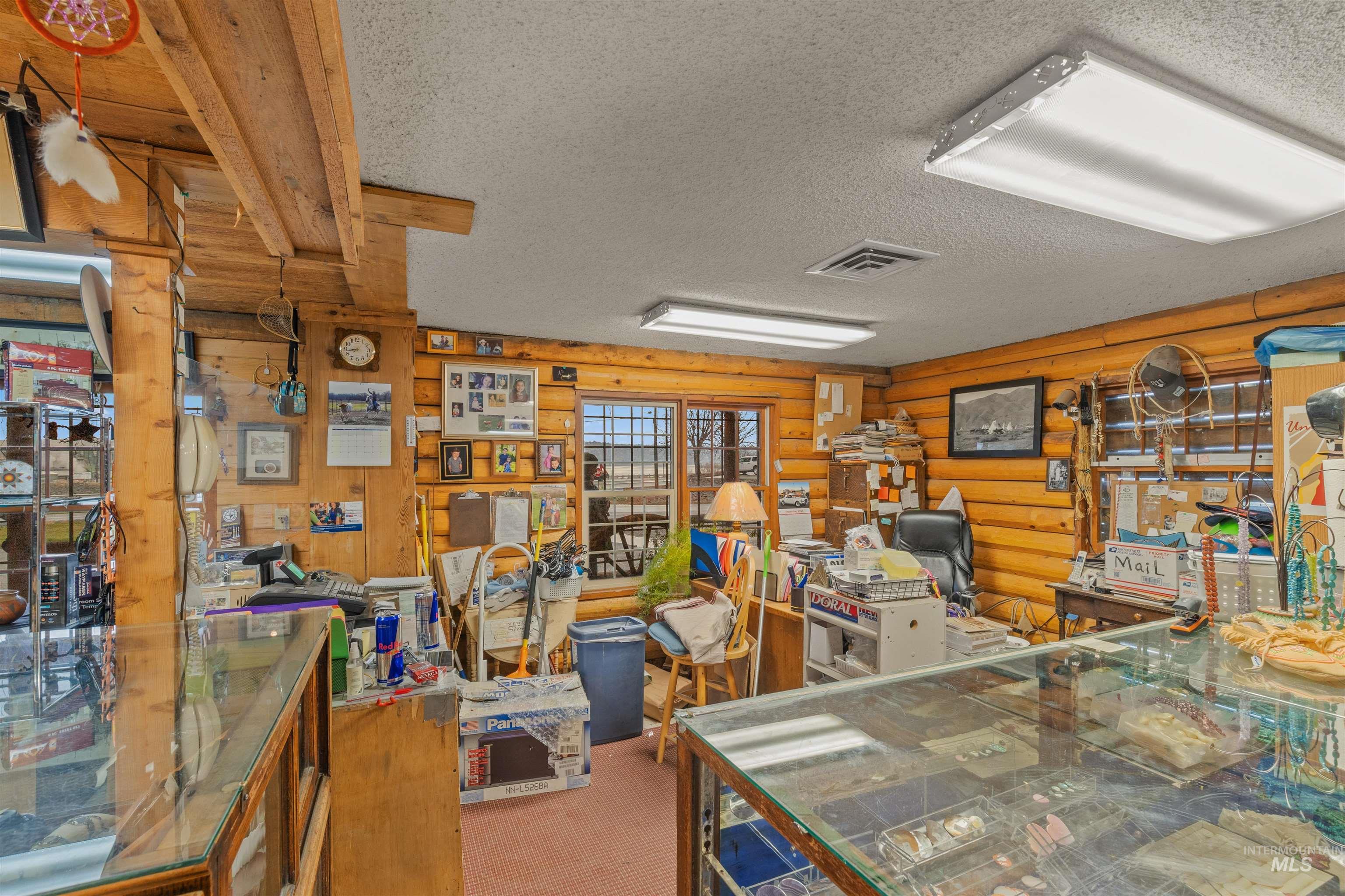 Office area featuring a textured ceiling and rustic walls