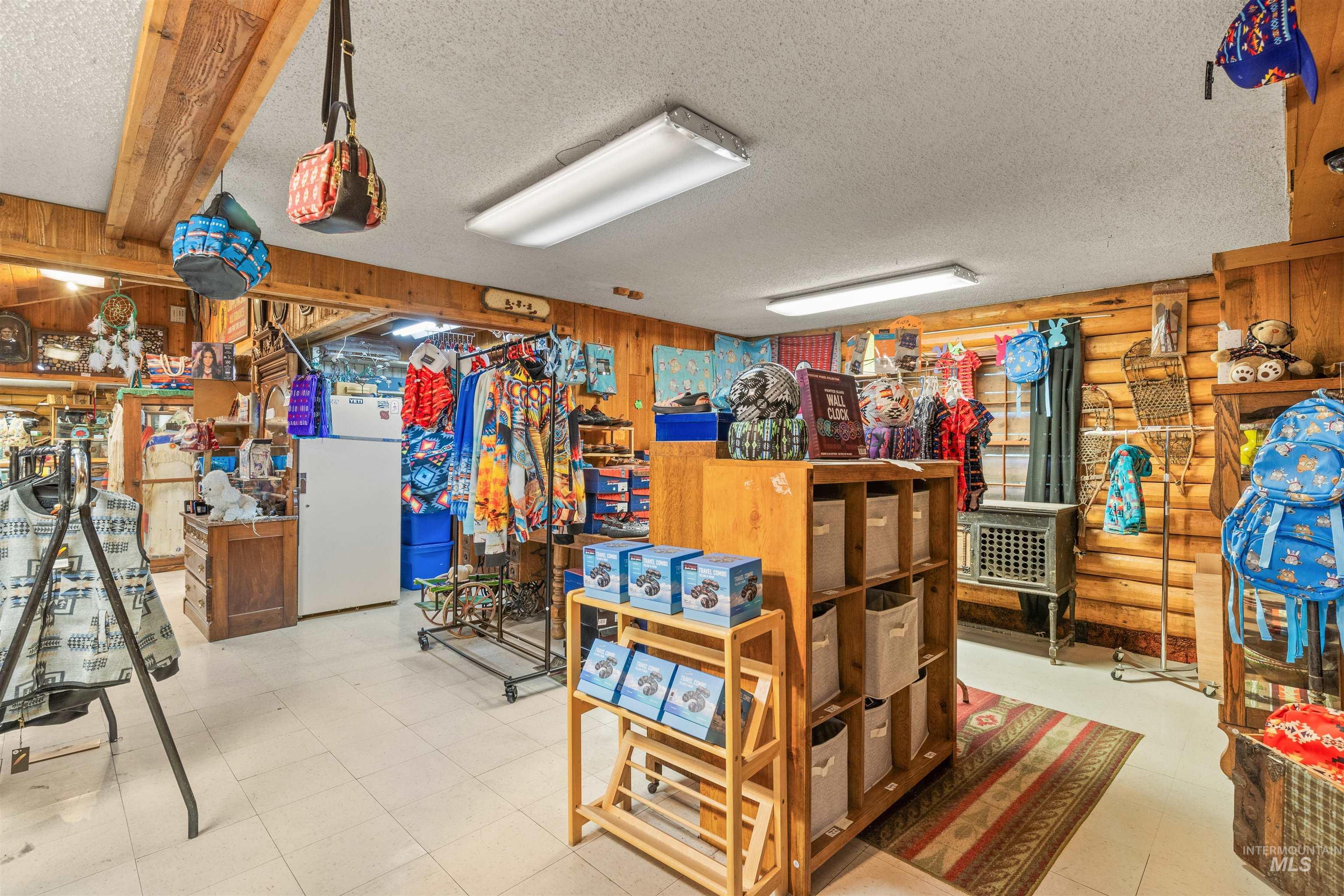 Misc room with wood walls, a textured ceiling, and rustic walls